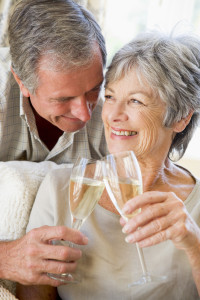 Couple in living room toasting champagne and smiling